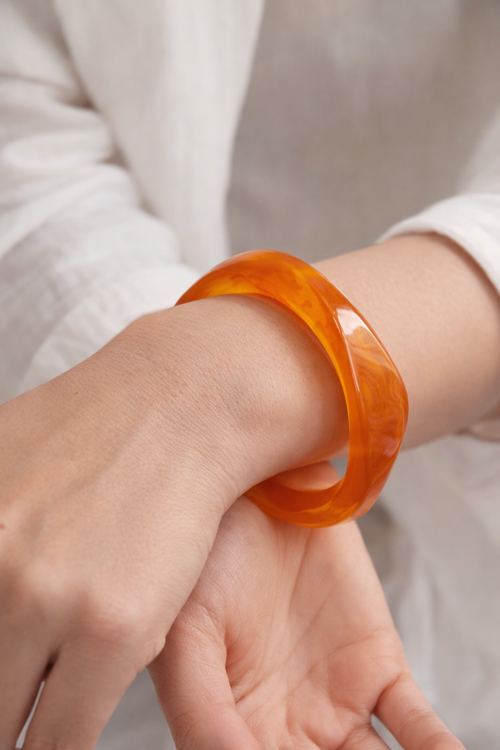 Amber orange chunky bangle bracelet with glossy sculptural design