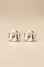 Pair of  posts with '925' stamp on a beige background