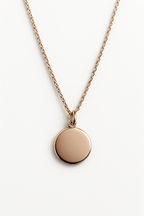 Rose gold necklace with a round pendant on a white background