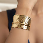 Close-up of a person wearing a anti tarnish adjustable  leaf textured golden cuff on their wrist.