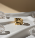 Close-up of an anti  tarnish adjustable  leaf textured golden cuff on plain background.