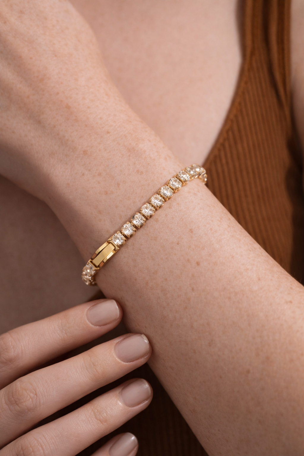 Woman wearing gold oval crystal tennis bracelet, elegant luxury jewelry close-up