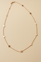 polka dots Rose gold necklace  on a beige background