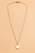 Necklace with a black pendant on a beige background