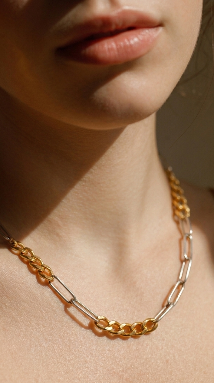 Close-up of a person wearing a gold chain necklace with a soft focus on the face.