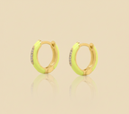 Pair of neon yellow hoop earrings with gold accents on a beige background