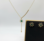 Cose up of Person wearing an anti-tarnish sunflower necklace with a green crystal.