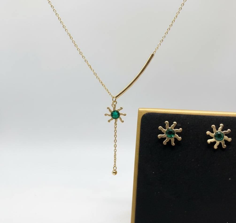Cose up of Person wearing an anti-tarnish sunflower necklace with a green crystal.
