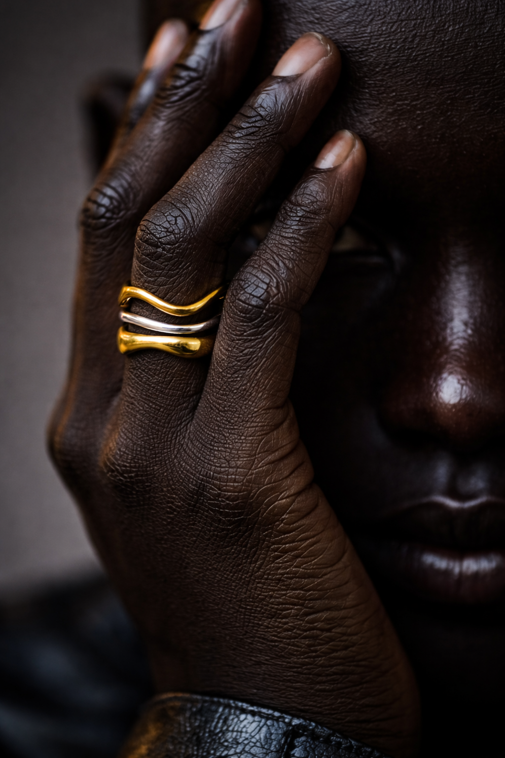 close up of woman wearing adjustable wavy ring in two tones. 