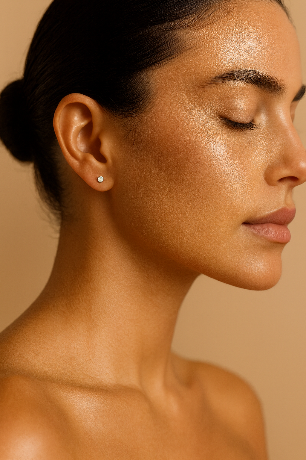 Close-up of a woman wearing sterling silver opal stud earrings.