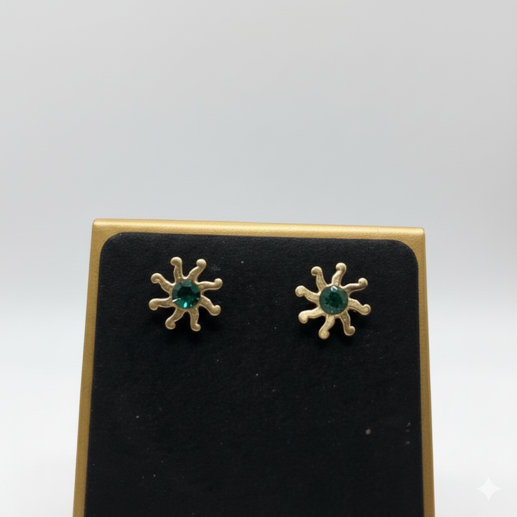 Cose up of  earrings of an anti-tarnish sunflower necklace with a green crystal.